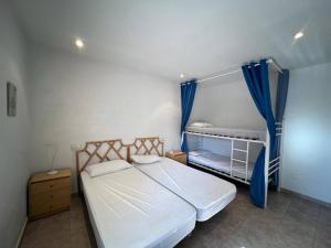 a small bedroom with a bed with blue curtains at Casa Buckingham 27b in Torroella de Montgrí