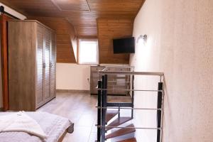 a room with a bed and a tv on a wall at Tisza Apartman Mártély in Mártély
