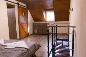 a small room with a bed and a wooden ceiling at Tisza Apartman Mártély in Mártély