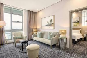 a hotel room with a bed and a couch at Protea Hotel by Marriott Durban Umhlanga in Durban +43 photos