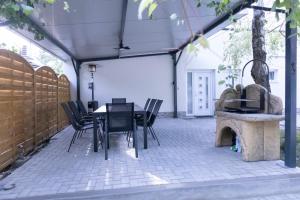 a patio with a black table and chairs at Tisza Apartman Mártély in Mártély