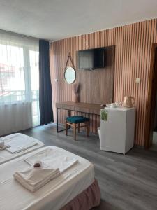 ein Hotelzimmer mit Bett und Fernseher in der Unterkunft Dreams Family Hotel in Nessebar
