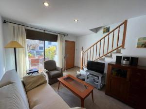 a living room with a couch and a tv at Sol Ric 13 in Torroella de Montgrí