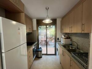 a kitchen with a white refrigerator and a sink at Sol Ric 13 in Torroella de Montgrí +10 photos