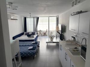 a kitchen and living room with a couch and a table at Apartment with private pool in Ashkelon