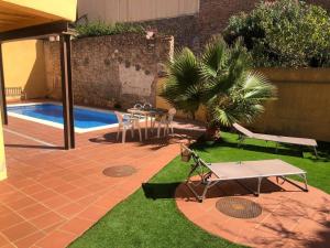 a patio with a table and chairs next to a pool at Ground floor apartment in Centre of Torroella De Montgri in Torroella de Montgrí