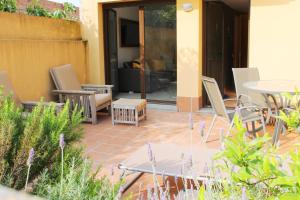a patio with chairs and a table and a table at Ground floor apartment in Centre of Torroella De Montgri in Torroella de Montgrí