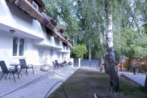 a patio with chairs and a table next to a house at Tisza Apartman Mártély in Mártély