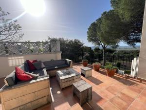 a patio with a couch and tables and a fence at Torre Vella 66 in Torroella de Montgrí