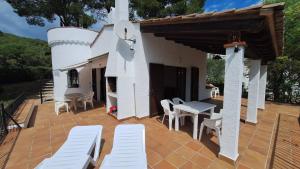 a patio with white chairs and a table and a building at TV 57 privat pool in Torroella de Montgrí