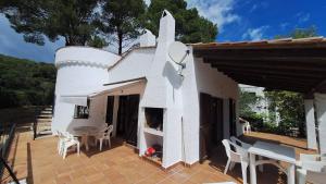 a white house with a table and chairs on a patio at TV 57 privat pool in Torroella de Montgrí