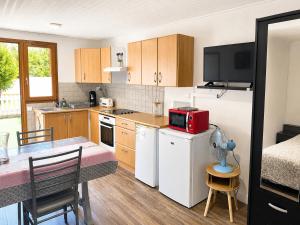 a kitchen with a table and a small kitchen with a tableablish at Maisonnette cosy avec jardinet et parking privatif in Gréoux-les-Bains