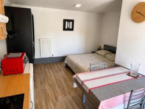 a small room with two beds and a table in it at Maisonnette cosy avec jardinet et parking privatif in Gréoux-les-Bains