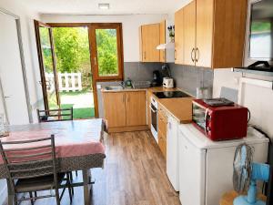 a kitchen with a table and a red appliance at Maisonnette cosy avec jardinet et parking privatif in Gréoux-les-Bains +8 photos
