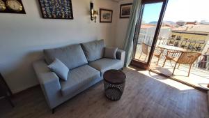 a living room with a couch and a balcony at La Font Lovely apartment LEstartit 400 meter from the beach in L'Estartit