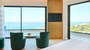 a room with two chairs and a view of the ocean at Sunrise Emerald in Protaras