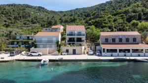 a house on the water with a boat in the water at Azure Adriatic in Prožura