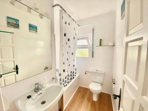 a white bathroom with a sink and a toilet at Alemanya 38 in Torroella de Montgrí
