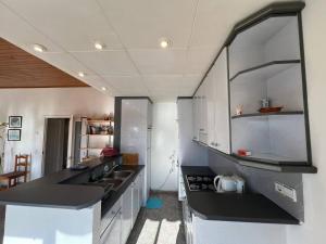 a kitchen with white cabinets and a black counter top at Casa Buckingham 27C in Torroella de Montgrí