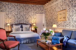 a bedroom with a bed and a couch and a table at Hotel d'Angleterre in Paris