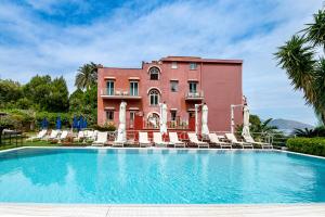 a house with a swimming pool in front of a building at Palatium Mari in Capri