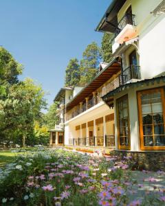 a building with flowers in front of it at WelcomHeritage Ashdale in Nainital