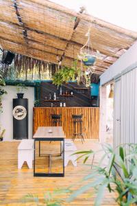 a patio with a table and chairs and a bar at Piano Piano hostel in Pipa