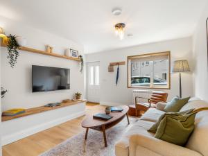 a living room with a couch and a tv at The Old Forge Clifden in Clifden