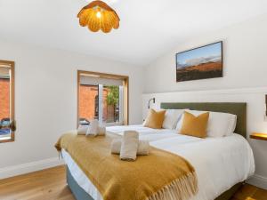 a bedroom with a large white bed with a large window at The Old Forge Clifden in Clifden