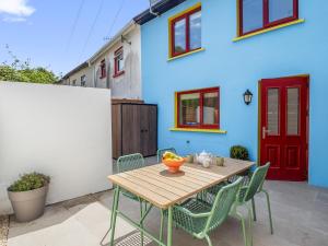a wooden table and chairs in front of a house at The Old Forge Clifden in Clifden