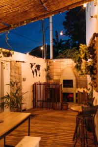 an outdoor deck with a table and chairs and a fireplace at Piano Piano hostel in Pipa