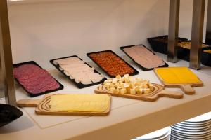 a counter with different types of cheese and other foods at Muthu La Perla Tenerife in Puerto de la Cruz