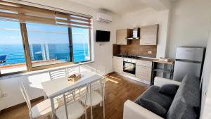 a kitchen and a living room with a table and chairs at Sole E Mare in Marina di Fuscaldo