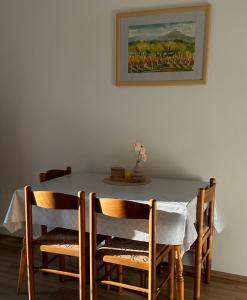 a dining room table with chairs and a painting on the wall at Tomajna Vineyard Stay in Podlehnik +24 photos