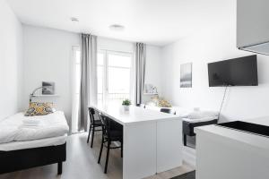 a white apartment with a kitchen and a living room at Hiisi Homes Turku Fleminginkatu in Turku