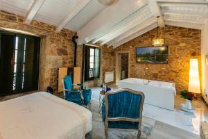 a bedroom with a bed and a stone wall at Casa de Lema Boutique in Muxia +80 photos