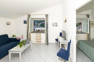 a bedroom with a blue couch and a desk and a bed at Palatium Mari in Capri