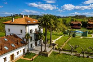 an aerial view of a house with a palm tree at Tejasturias |Piscina, Pádel y Playa de La Franca in Noriega
