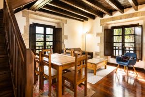 a dining room with a wooden table and chairs at Tejasturias |Piscina, Pádel y Playa de La Franca in Noriega
