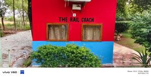 a red and blue building with a sign on it at The Rail Coach in Jhānsi