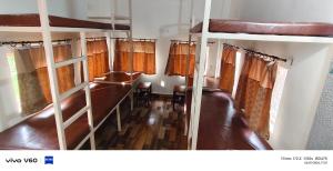a room with two bunk beds and a table at The Rail Coach in Jhānsi