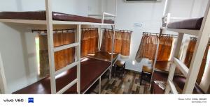 a room with several bunk beds in a room at The Rail Coach in Jhānsi