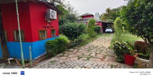 a red and blue house next to a brick road at The Rail Coach in Jhānsi
