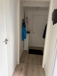 a hallway with a white door and a blue jacket at Quiet Apartment in Horsens in Horsens