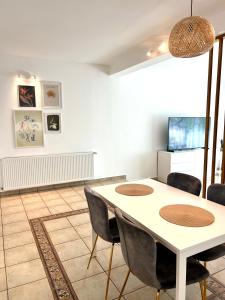 a dining room with a white table and chairs at Central Loft Studio Târgoviște in Târgovişte