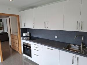 a kitchen with white cabinets and a sink at Ferienwohnung Am Anger in Unterleinach