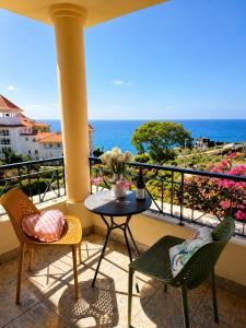 a balcony with a table and chairs and the ocean at Ocean Breeze in Caniço