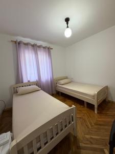 a room with two beds and a window at Guest House Central Vlora in Vlorë