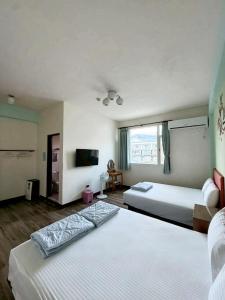 a hotel room with two beds and a television at 池上投優榻 Smart living B&B in Chishang +16 photos