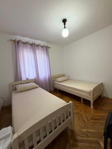two beds in a room with purple curtains at Guest House Central Vlora in Vlorë